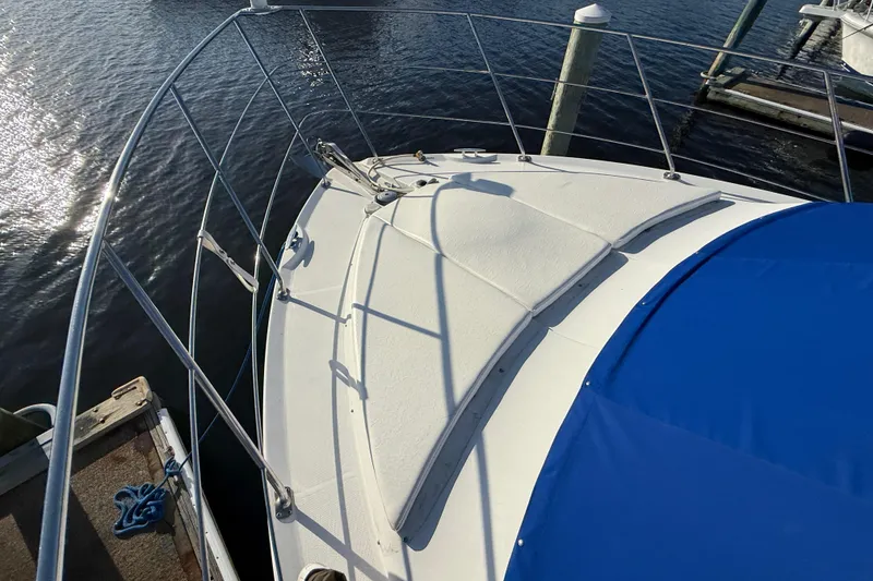 Slide: The Image of 2005 Carver 36 Sedan yacht bow with blue cover, docked on calm water. - 27