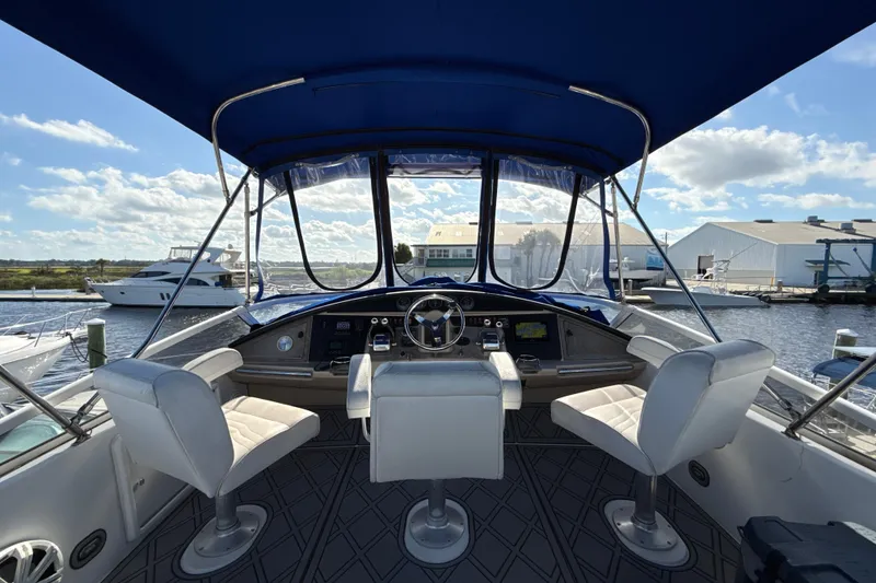 Slide: The Image of 2005 Carver 36 Sedan helm with blue canopy, docked at marina under clear sky. - 28