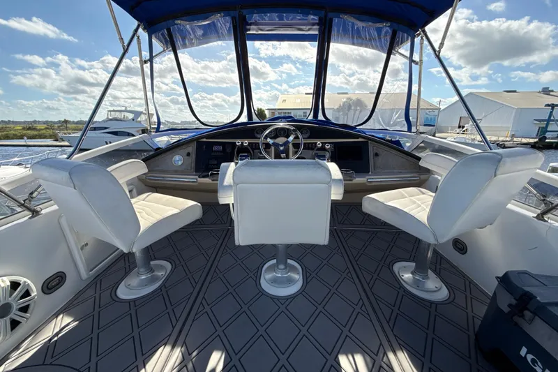Slide: The Image of 2005 Carver 36 Sedan helm with white seating and panoramic marina view. - 29