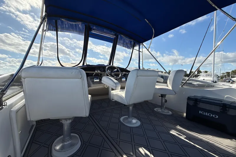 Slide: The Image of Interior view of 2005 Carver 36 Sedan yacht with white seating and blue canopy. - 37