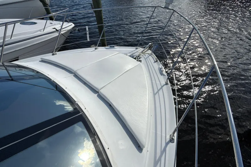 Slide: The Image of 2005 Carver 36 Sedan yacht bow with sun pad, docked on calm water. - 40