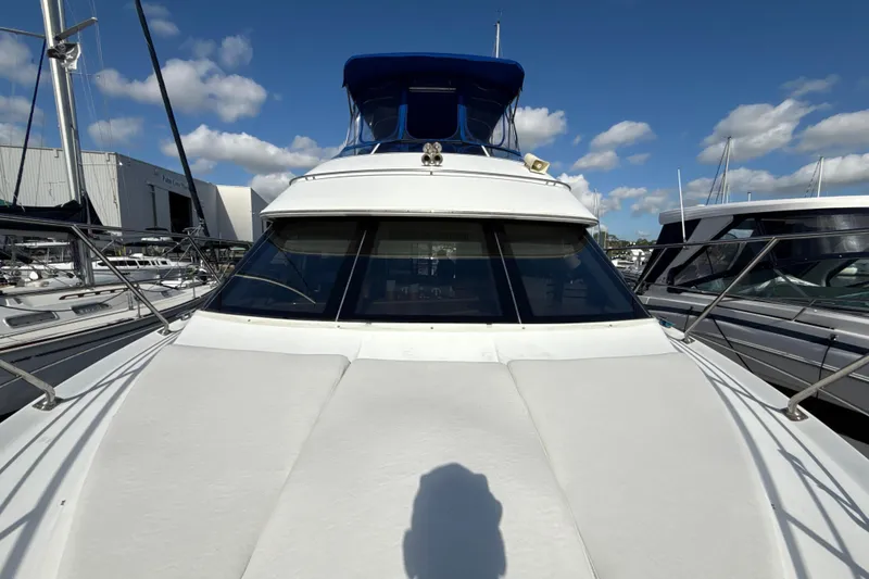 Slide: The Image of 2005 Carver 36 Sedan yacht with blue canopy, docked under clear skies. - 41