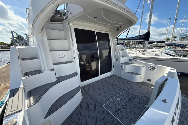 Slide: The Image of 2005 Carver 36 Sedan yacht deck with stairs, marina view, and sleek design. - 43