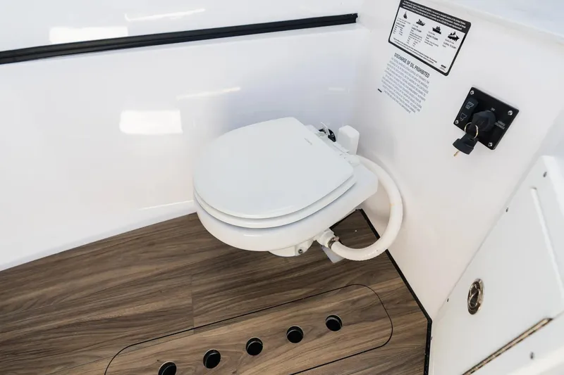 Slide: The Image of 2026 Sportsman Heritage 321 Center Console boat interior with modern marine toilet. - 9