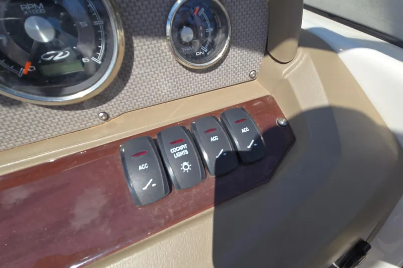 Slide: The Image of Dashboard controls of a 2015 Regal 1900 Bowrider boat, featuring cockpit lights and accessory switches. - 24