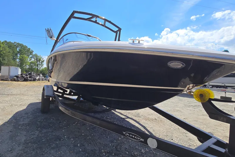 Slide: The Image of 2015 Regal 1900 Bowrider boat on trailer under clear blue sky. - 4