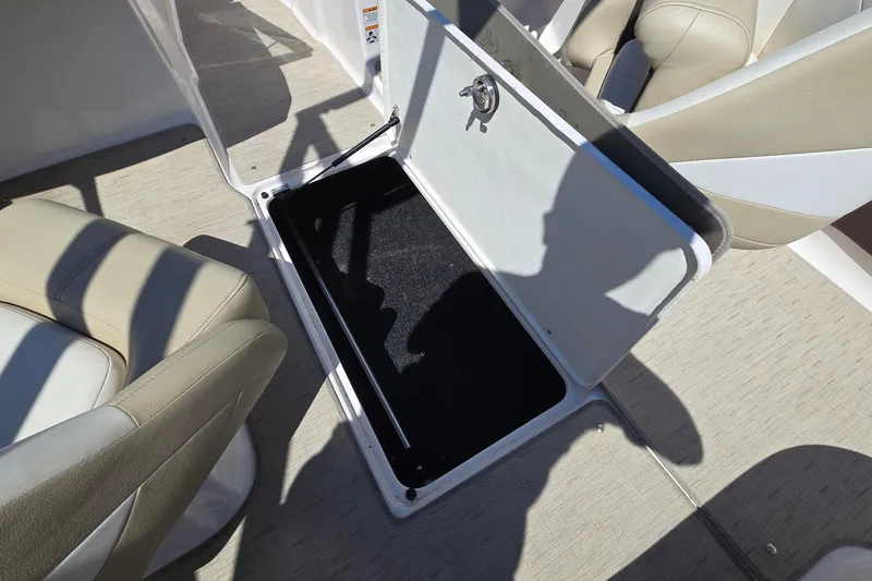 Slide: The Image of 2015 Regal 1900 Bowrider storage compartment with open hatch and beige seating. - 9