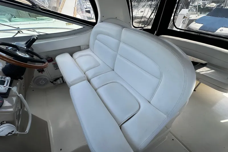 Slide: The Image of Interior of 2005 Sea Ray 300 Sundancer with white seating and steering wheel. - 15