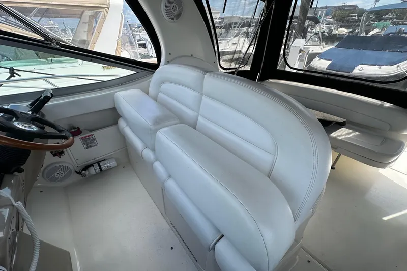 Slide: The Image of 2005 Sea Ray 300 Sundancer interior with white leather seating and steering wheel. - 16
