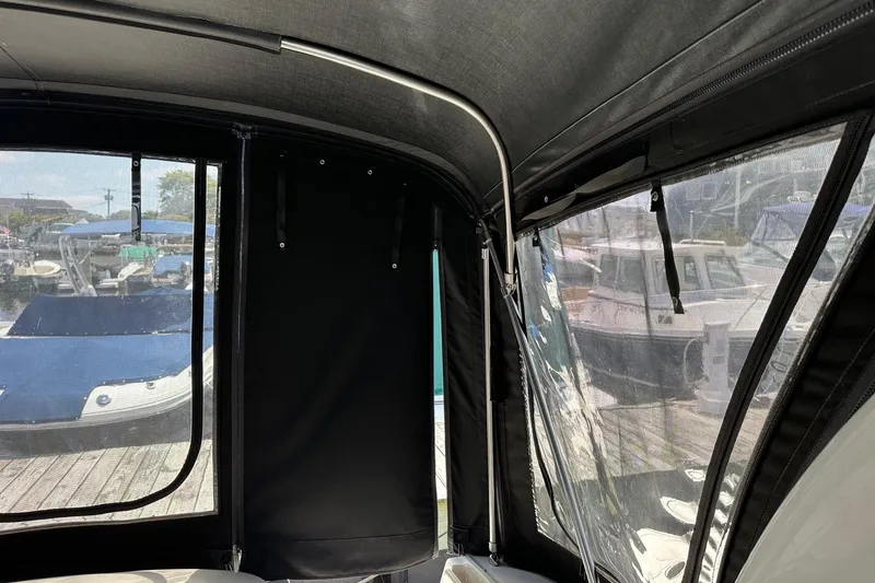 Slide: The Image of 2005 Sea Ray 300 Sundancer interior with marina view through clear and black canvas covers. - 21