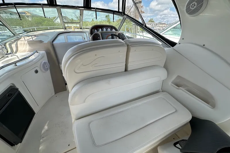 Slide: The Image of Interior of 2005 Sea Ray 300 Sundancer boat with white seating and dashboard. - 22