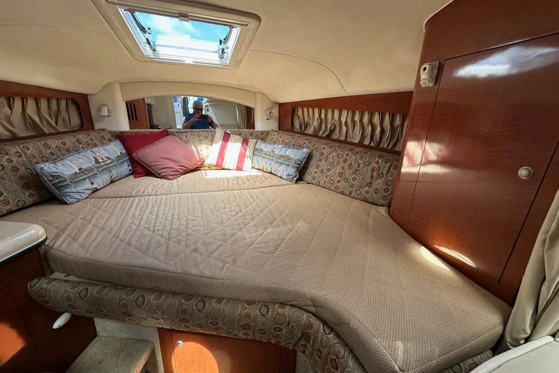 Slide: The Image of Interior cabin of 2005 Sea Ray 300 Sundancer with cozy bedding and decorative pillows. - 25