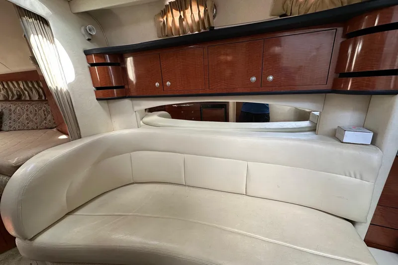 Slide: The Image of Interior of 2005 Sea Ray 300 Sundancer with cream leather seating and wooden cabinetry. - 27