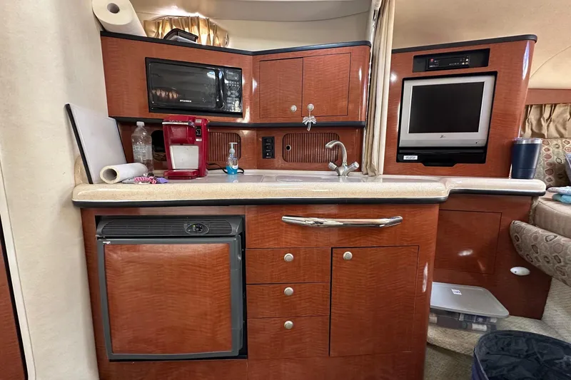 Slide: The Image of Interior of 2005 Sea Ray 300 Sundancer with kitchenette, microwave, and TV. - 28