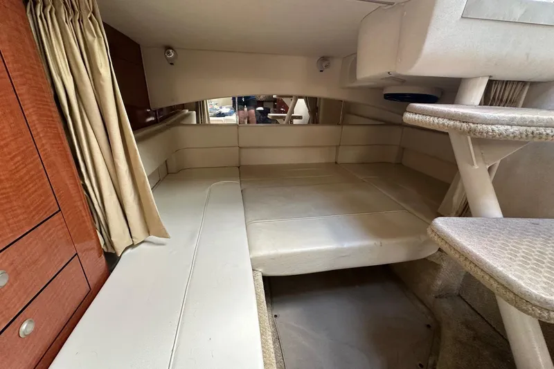 Slide: The Image of Interior cabin of 2005 Sea Ray 300 Sundancer with beige seating and wooden cabinetry. - 32
