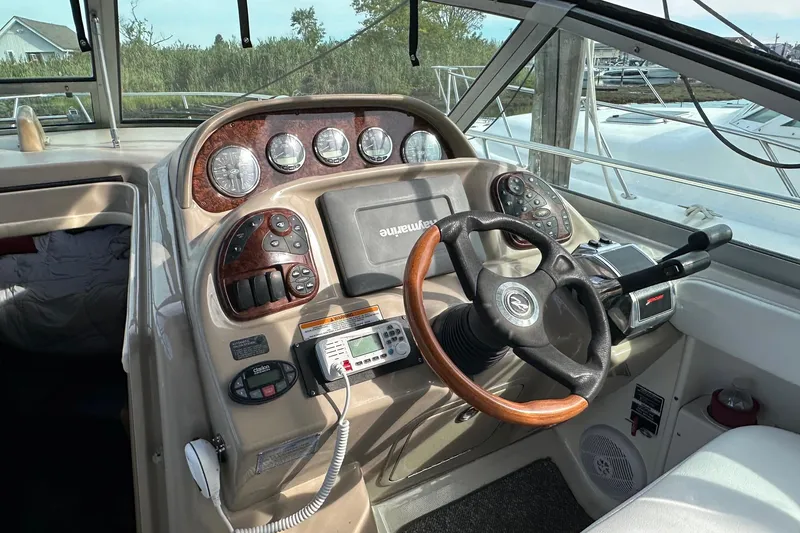 Slide: The Image of 2005 Sea Ray 300 Sundancer boat dashboard with steering wheel and control panel. - 4