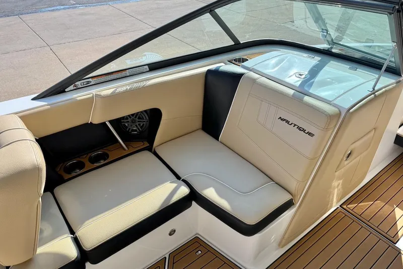 Slide: The Image of 2020 Nautique Super Air Nautique 230 interior with beige seating and cup holders. - 15