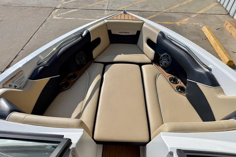 Slide: The Image of 2020 Nautique Super Air Nautique 230 boat interior with beige and black seating. - 16