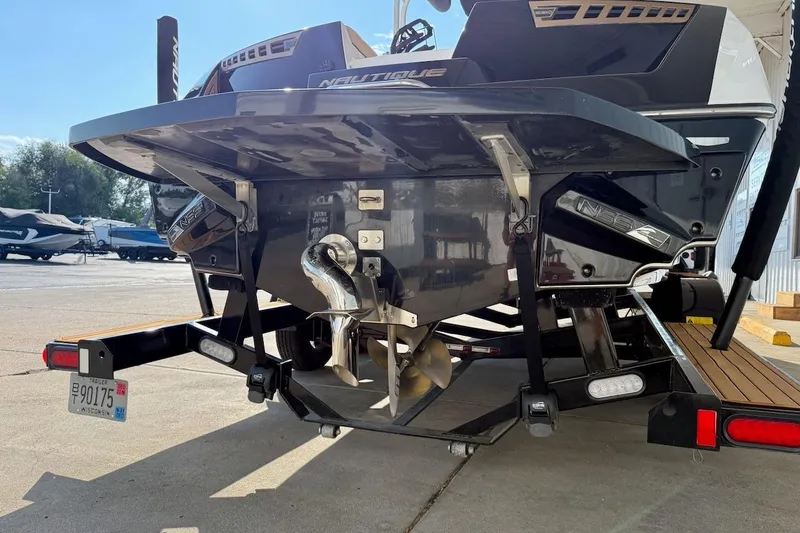 Slide: The Image of 2020 Nautique Super Air Nautique 230 boat rear view with propeller and trailer. - 5