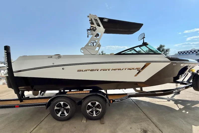 Slide: The Image of 2020 Nautique Super Air Nautique 230 boat on trailer, side view, sunny day. - 8