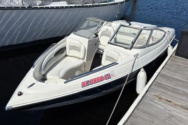 The Image of 2008 Stingray 185 LX boat docked on calm water, featuring sleek white design and comfortable seating. - 0