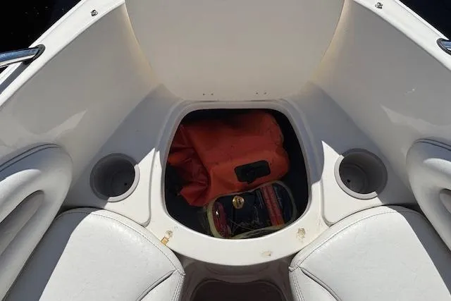 Slide: The Image of 2008 Stingray 185 LX boat interior with storage compartment and cup holders. - 14