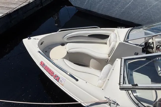 Slide: The Image of 2008 Stingray 185 LX boat docked, featuring white interior seating and sleek design. - 8