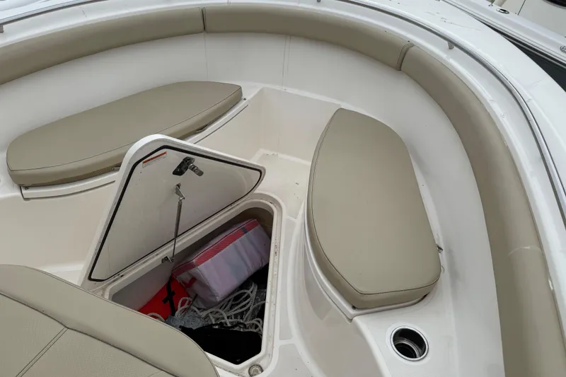 Slide: The Image of 2016 Pursuit C 280 Center Console boat with open storage compartment and cushioned seating. - 11