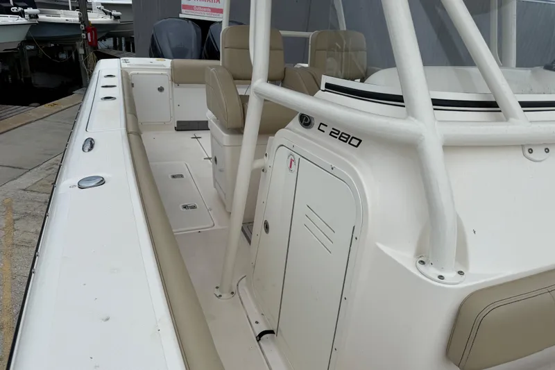 Slide: The Image of 2016 Pursuit C 280 Center Console boat with beige seating and white deck. - 12