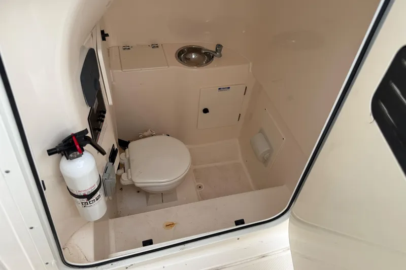 Slide: The Image of 2016 Pursuit C 280 Center Console boat interior with toilet and sink. - 14
