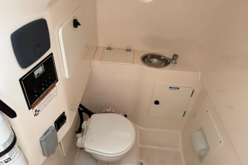 Slide: The Image of 2016 Pursuit C 280 Center Console boat interior with toilet and sink. - 15