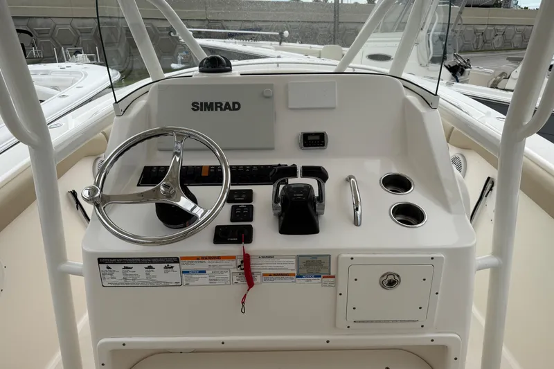 Slide: The Image of 2016 Pursuit C 280 Center Console boat dashboard with steering wheel and controls. - 6