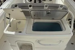 Slide: The Image of 2015 Mako 284 Center Console boat with open storage compartments and rod holders. - 16