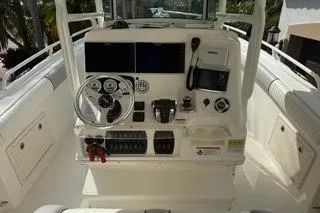 Slide: The Image of 2015 Mako 284 Center Console boat dashboard with steering wheel and controls. - 17