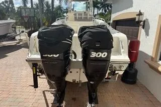 Slide: The Image of 2015 Mako 284 Center Console boat with twin 300 horsepower engines, parked outdoors. - 2