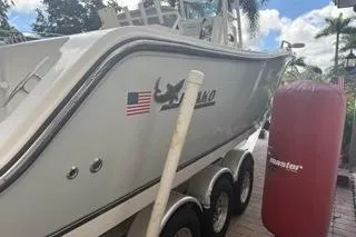 Slide: The Image of 2015 Mako 284 Center Console boat on trailer, parked outdoors. - 22