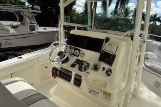Slide: The Image of 2015 Mako 284 Center Console boat interior with steering wheel and control panel. - 5