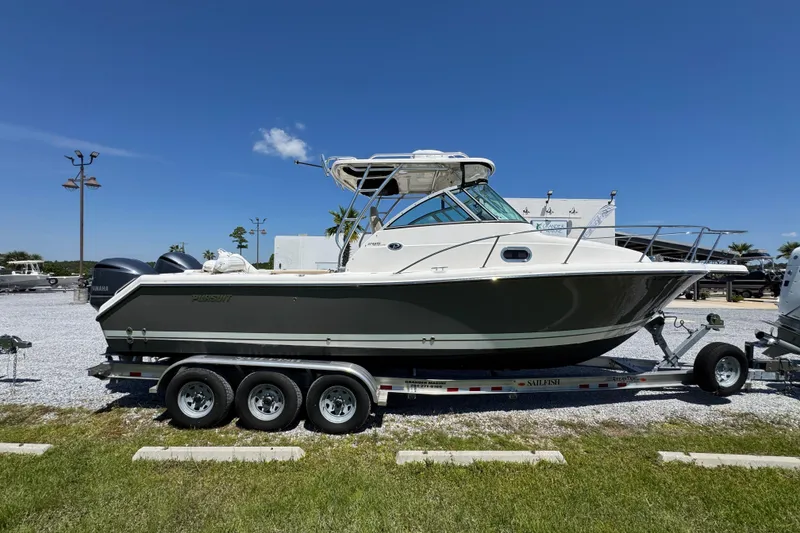 Slide: The Image of 2015 Pursuit OS 285 Offshore boat on trailer, parked outdoors under clear blue sky. - 10