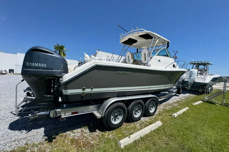 Slide: The Image of 2015 Pursuit OS 285 Offshore boat on trailer with Yamaha engine, parked outdoors. - 12