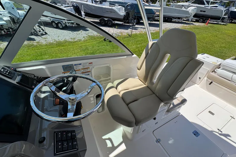 Slide: The Image of 2015 Pursuit OS 285 Offshore boat helm with steering wheel and captain's chair. - 22