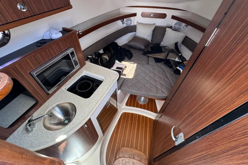 Slide: The Image of 2015 Pursuit OS 285 Offshore cabin with kitchenette, sink, and cozy seating area. - 26