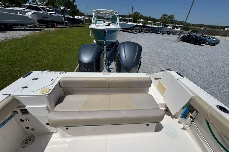 Slide: The Image of 2015 Pursuit OS 285 Offshore boat with dual engines, parked on gravel lot. - 34