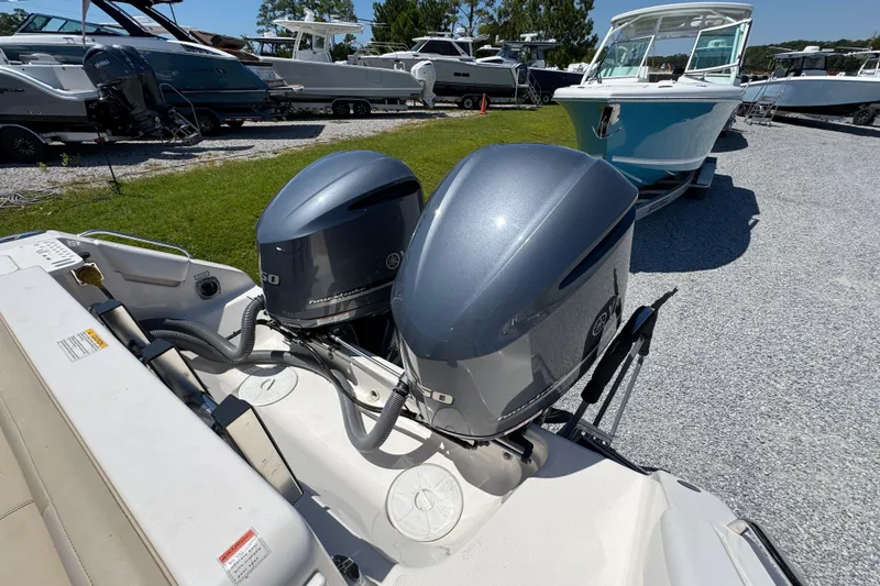 Slide: The Image of 2015 Pursuit OS 285 Offshore boat with dual outboard engines in a marina setting. - 38