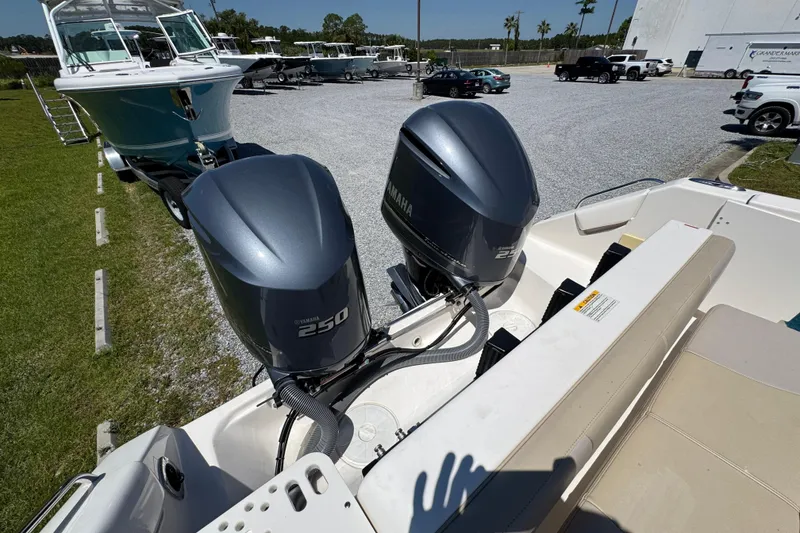 Slide: The Image of 2015 Pursuit OS 285 Offshore boat with dual Yamaha 250 engines in a parking area. - 39