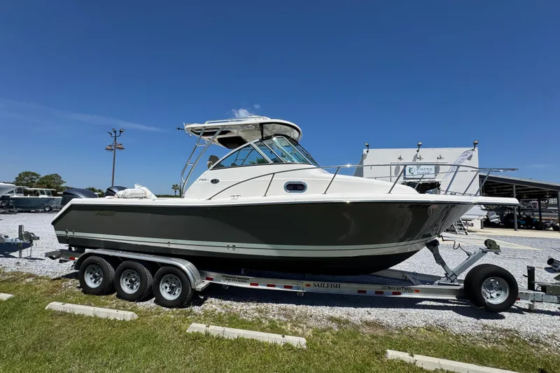 Slide: The Image of 2015 Pursuit OS 285 Offshore boat on trailer under clear blue sky. - 9