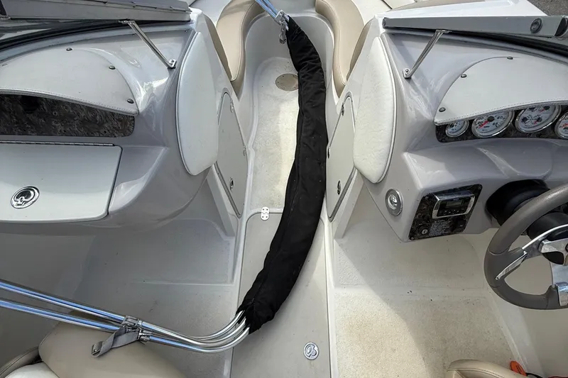 Slide: The Image of Interior of a 2014 Stingray 208 LR boat, featuring dashboard and seating area. - 10