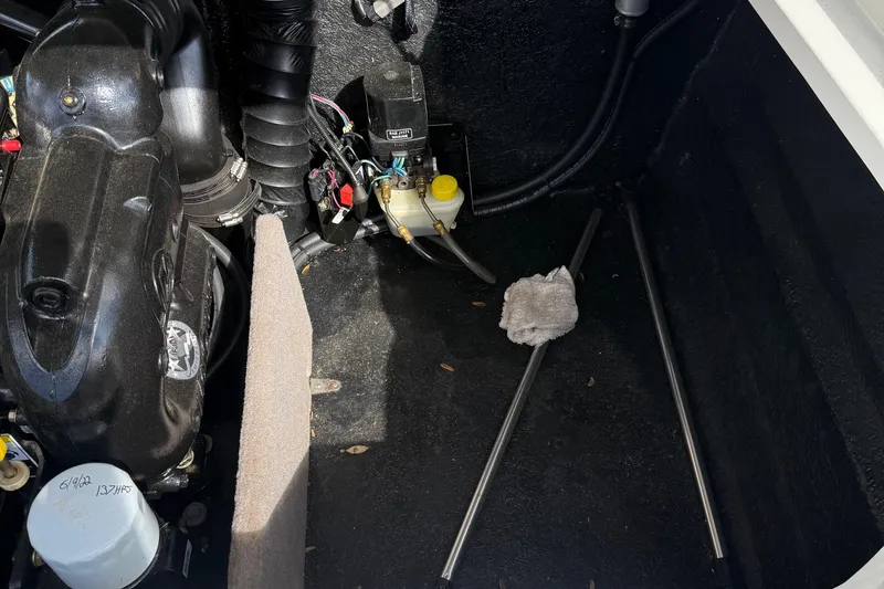 Slide: The Image of Engine compartment of a 2014 Stingray 208 LR boat, showing mechanical components and wiring. - 17