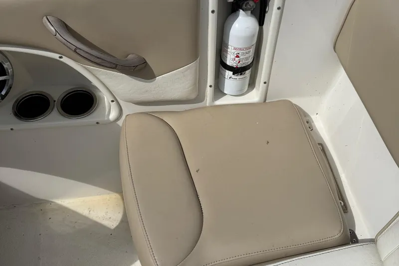 Slide: The Image of 2014 Stingray 208 LR boat interior with beige seat and fire extinguisher. - 20
