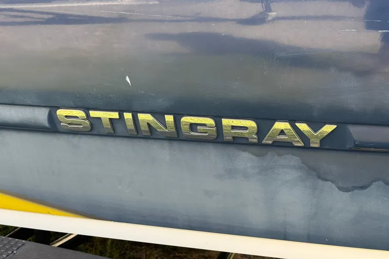 Slide: The Image of 2014 Stingray 208 LR boat logo on a weathered surface. - 4