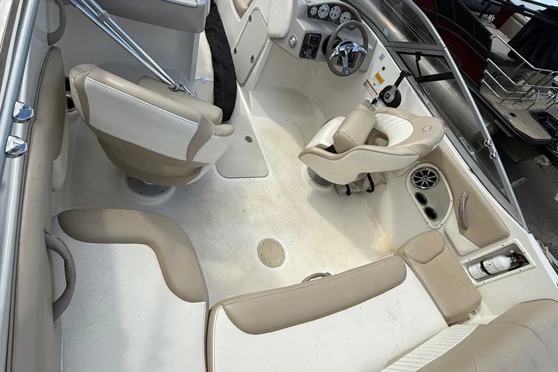 Slide: The Image of Interior of a 2014 Stingray 208 LR boat with beige seating and steering console. - 6